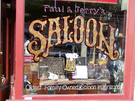 A window of a saloon with the name " paul & jerry 's saloon ".