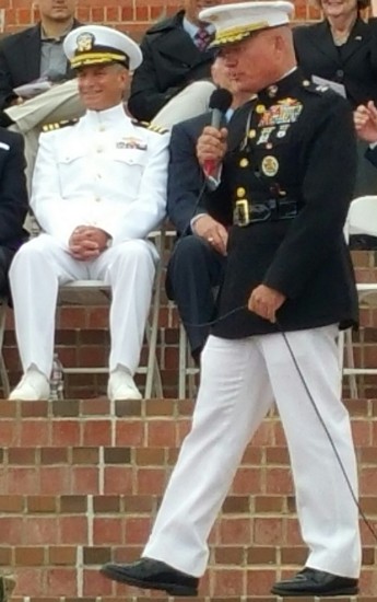 A man in military uniform holding a microphone.