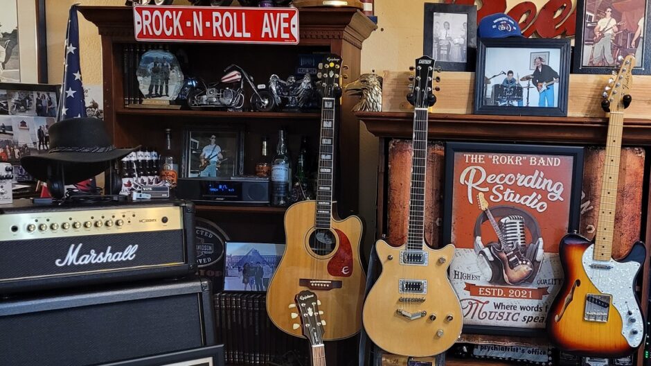Two guitars are sitting in a room with other memorabilia.